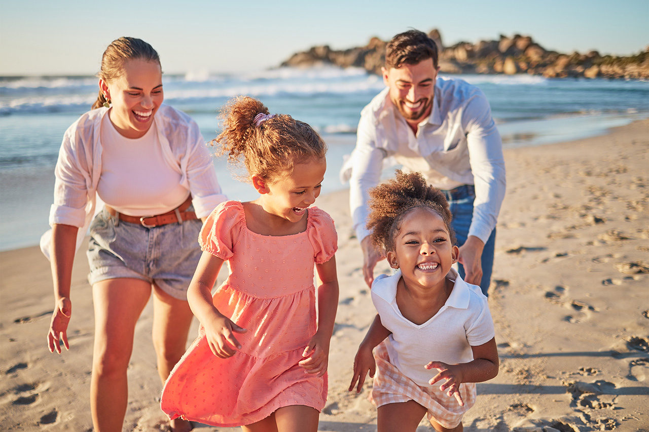 Happy family running on the beach, enjoying a fun-filled vacation.